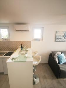 uma cozinha e sala de estar com uma mesa e um sofá em Rita Apartments - Sea-view apartment 2plus1 em Tučepi
