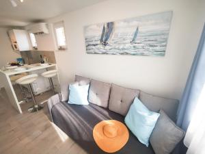 a living room with a couch with a hat on it at Rita Apartments - Sea-view apartment 2plus1 in Tučepi