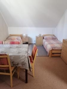 a room with two beds and a table and chairs at ubytování v apartmánu in Mladkov