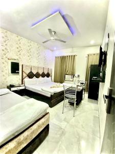 a hotel room with two beds and a table and chairs at Swaran hotel in Amritsar