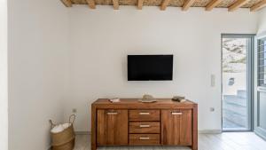 a living room with a tv on a wall at Casa del Mar Milos in Kástron