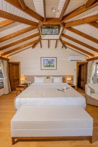 Schlafzimmer mit einem großen weißen Bett und Holzdecken in der Unterkunft Kairos Valley Health & Nature Resort in Datca