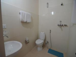 ein Badezimmer mit weißer Toilette und Waschbecken in der Unterkunft Hotel Asia in Pokhara + 46 Fotos