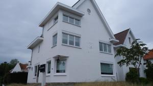 un edificio blanco con ventanas laterales en Villa Le Renard, en Knokke-Heist