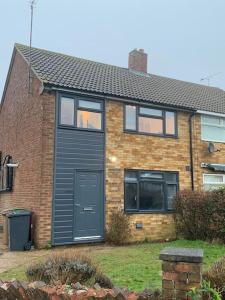a brick house with a black door and windows at Fabulous 4 bed 4 bath right by Luton Airport in Luton