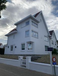a large white house on the side of a street at Villa Le Renard in Knokke-Heist