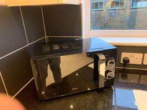 a microwave oven sitting on top of a counter at Fabulous 4 bed 4 bath right by Luton Airport in Luton