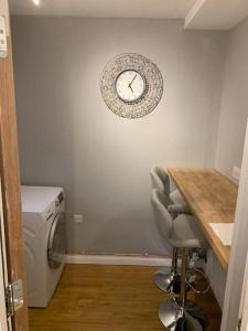 a kitchen with a counter and a clock on the wall at Fabulous 4 bed 4 bath right by Luton Airport in Luton