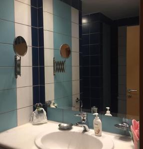 a bathroom with a sink and a mirror at Small apartment near Athens Airport in Pikérmion
