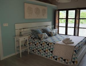 1 dormitorio con cama, mesa y ventanas en Casa gueli, en Cangas de Onís