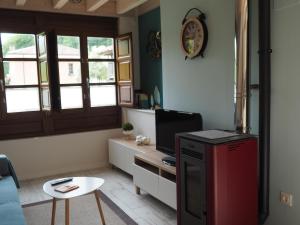 a living room with a red refrigerator and a table at Casa gueli in Cangas de Onís +15 photos
