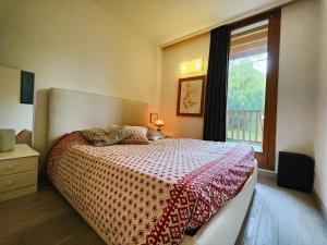 a bedroom with a large bed with a window at Hostdomus - Sansicario R21 in Cesana Torinese