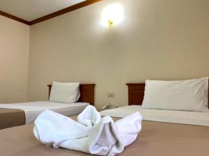 a room with two beds with white towels on them at Wantana Mansion in Hat Yai