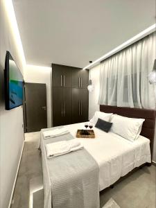 - une chambre avec un grand lit et une télévision dans l'établissement Flev's Luxury House with pool, à Kremasti