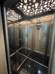 una fila de ascensores en un baño con luces en Julius Hotel, en Golem
