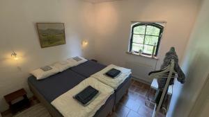 Schlafzimmer mit einem Bett und einem Fenster in der Unterkunft Stort rymligt boende med två sovrum och pentry i lantlig miljö in Höllviken
