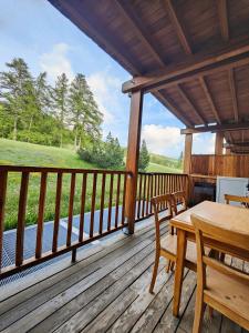 a porch of a cabin with a table and chairs at Hostdomus - Sansicario R21 in Cesana Torinese