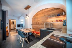kuchnia ze stołem i drewnianą ścianą w obiekcie Apartments Smidl w mieście Ortisei