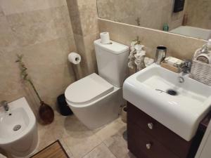 a bathroom with a white toilet and a sink at Indo Loma Sancti Petri in Chiclana de la Frontera