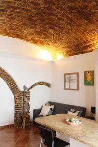 sala de estar con techo de piedra y mesa en Casa da Moeda, en Évora
