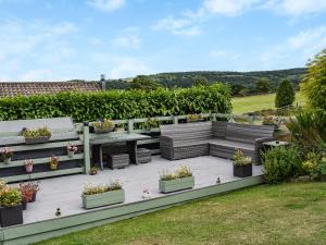 a deck with benches and potted plants on it at Ladybird Lodge in Glaisdale
