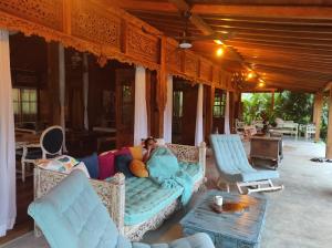 a person laying on a couch in a living room at Joglo Omah Kempalan, Private Pool Villa in Sentul, Bogor in Cimandala +65 photos