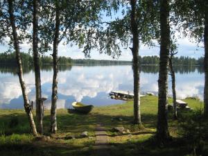 a small boat on the shore of a lake at Rinnepelto Holiday Cottages in Tahkovuori