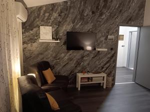 a living room with a couch and a tv on a wall at Apartman Dunav in Vukovar