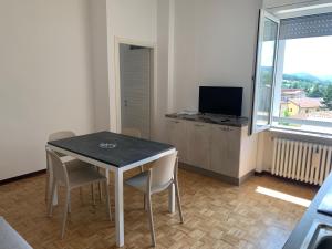 a dining room with a table and chairs and a television at Residence Salvatici in Castelnovo neʼ Monti