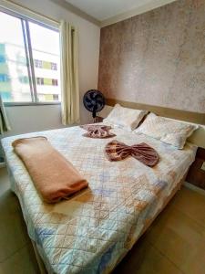 een bed met twee handdoeken en een raam bij Apartamento Aconchegante em Paulo Afonso in Paulo Afonso