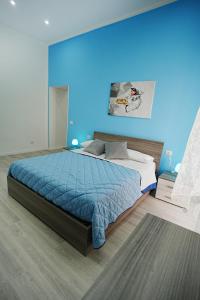een slaapkamer met een bed met een blauwe muur bij Just Like Home in Napels