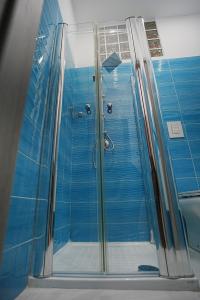 een badkamer met een douche met blauwe tegels bij Just Like Home in Napels