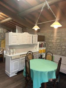 a dining room with a table and a kitchen at Le Mulina ristoro in Barberino di Mugello
