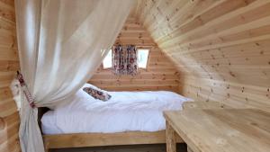 a bedroom in a log cabin with a bed and a table at Les Cabanes Flottantes in Givrauval
