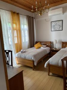 1 Schlafzimmer mit 2 Betten und einem Kronleuchter in der Unterkunft Hotel Gjirokastra in Gjirokastër