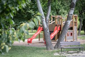 a playground with a red slide in a park at Apartments By Pyramid - Michal in Bratislava