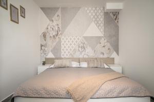 a bedroom with a large bed with a wall at Apartments By Pyramid - Michal in Bratislava