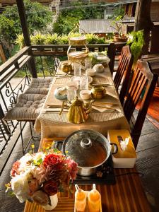 - une table avec un bol de nourriture sur la terrasse dans l'établissement บ้านพักกึ๊ดเติง แม่กำปอง เชียงใหม่, à Mae On
