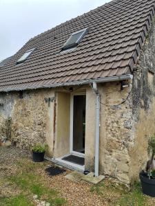 Casa de piedra con ventana y techo en La dépendance, petite maison au calme, en Vallon-sur-Gée