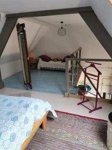 a attic room with a bed and a room with at La dépendance, petite maison au calme in Vallon-sur-Gée