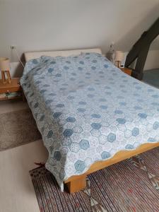 Schlafzimmer mit einem Bett mit blauer Decke in der Unterkunft La dépendance, petite maison au calme in Vallon-sur-Gée