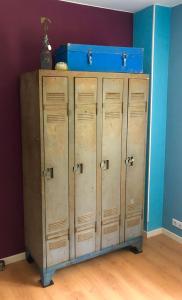 a wooden locker with a blue box on top of it at Superbes appartements in Mimizan