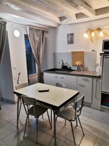 a kitchen with a table and chairs in a room at La dépendance, petite maison au calme in Vallon-sur-Gée