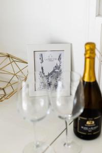 a bottle of wine next to two wine glasses at Glamroom Vatican Apartment in Rome