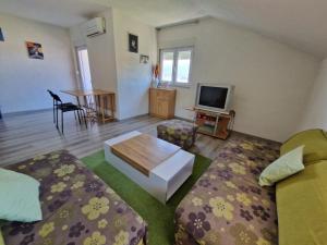 a living room with two beds and a tv at Sweet guesthouse in Mostar
