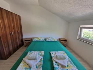 1 dormitorio con 1 cama con 2 almohadas y ventana en Sweet guesthouse, en Mostar