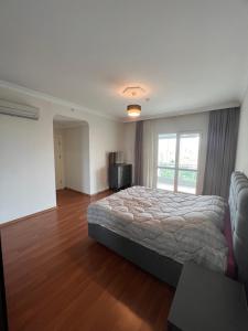 a bedroom with a bed and a large window at Akkoza Koru Bloklari in Esenyurt