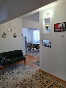 Una sala de estar con un sofá verde y una mesa. en Apartament Central, en Gherla