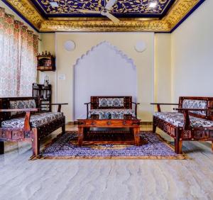 Una habitación con tres camas y una mesa dentro. en Hotel Dev Palace, en Sawāi Mādhopur