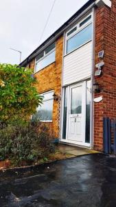 a brick house with a white garage door on it at Superb 4 Bed 4 Bath House Right by Luton Airport in Luton